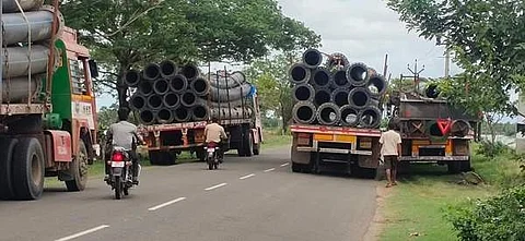 ஆதனூரில் நிறுத்தி வைக்கப்பட்டுள்ள ராட்சத குழாய்களுடன் வந்த லாரிகள்.