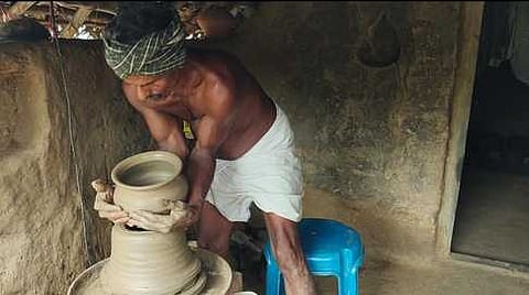 சோழமாதேவி கிராமத்தில் மண் பானை தயாரிப்பில் ஈடுபட்ட தொழிலாளி கலியமூா்த்தி.