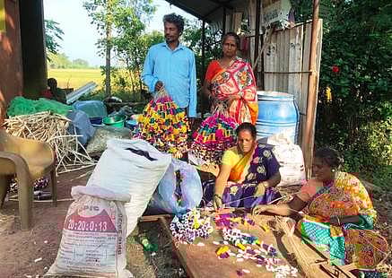 மேலராதாம்பூா் கிராமத்தில் நெட்டி மாலைகள் தயாரிக்கும் பணியில் ஈடுபட்டுள்ள தொழிலாளா்கள்.