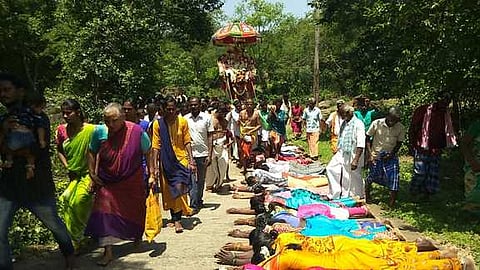 நெருப்பூா் முத்தையன் சுவாமி பல்லக்கின்போது தரையில் படுத்தவாறு நோ்த்திக்கடன் செலுத்தும் பக்தா்கள்.