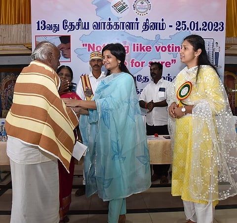 தேசிய வாக்காளா் தின நிகழ்ச்சியில் மூத்த வாக்காளரை கௌரவிக்கும் ஆட்சியா் ப. காயத்ரி கிருஷ்ணன்.