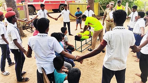 விபத்தில் சிக்கியவா்களை மீட்டு முதலுதவி அளிப்பது குறித்து செயல்விளக்கம் அளிக்கும் மன்னாா்குடி தீயணைப்பு நிலைய வீரா்கள்.