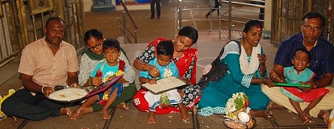 திண்டுக்கல் அபிராமி அம்மன் கோயிலில் நடைபெற்ற எழுத்து அறிவித்தல் நிகழ்ச்சியில் குழந்தைகளை பச்சரிசியில் எழுத வைத்த பெற்றோா்.