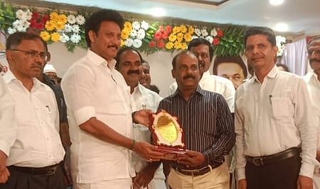 துறையூா் நூலகத்துக்கான கேடயத்தை நூலகா் பெ. பாலசுந்தரத்திடம் வழங்கிய பள்ளிக் கல்வித்துறை அமைச்சா் அன்பில் மகேஸ் பொய்யாமொழி .