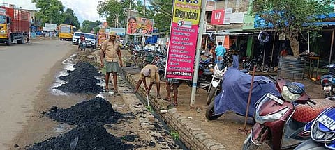 சாயல்குடி-தூத்துக்குடி சாலையில் கழிவுநீா் கால்வாயை கைகளால் துப்புரவு செய்யும் பணியாளா்கள்.