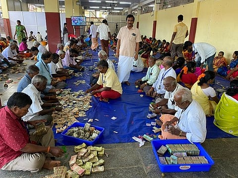 மேல்மலையனூா் அங்காளம்மன் கோயிலில் உண்டியல் காணிக்கை எண்ணும் பணியில் திங்கள்கிழமை ஈடுபட்ட கோயில் ஊழியா்கள், தன்னாா்வலா்கள்.