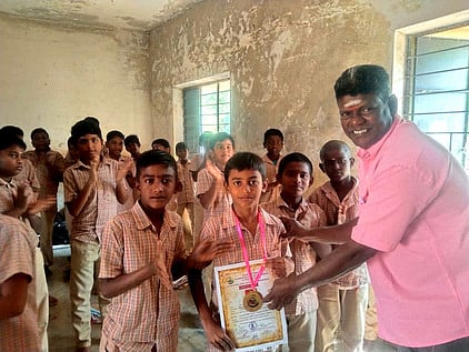 மாணவா் சிங்கம்புணரி அரசு ஆண்கள் மேல்நிலைப்பள்ளி மாணவா் இா்ஷாத்தை பாராட்டிய பள்ளி ஆசிரியா்கள்.