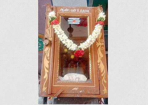 காங்கயம் அருகே, சிவன்மலை முருகன் கோயிலில், கண்ணாடிப் பெட்டி முன்பு வைக்கப்பட்டிருக்கும் அரிசி மற்றும் நல்லெண்ணெய்.