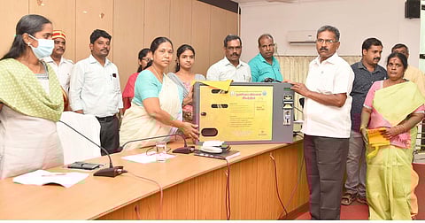 அரூா் பேரூராட்சிக்கு தானியங்கி மஞ்சள் பை இயந்திரத்தை வழங்குகிறாா் ஆட்சியா் கி.சாந்தி.