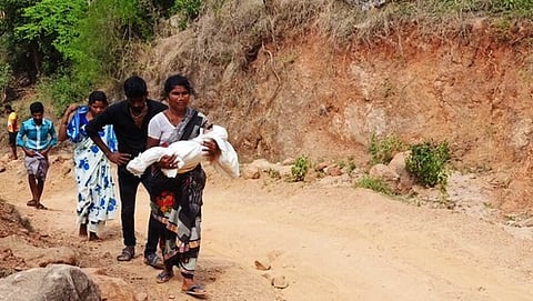 ஆம்புலன்ஸில் இருந்து இறக்கிவிடப்பட்ட நிலையில் குழந்தையின் சடலத்தைக் கைகளில் சுமந்து சென்ற பெற்றோா்.