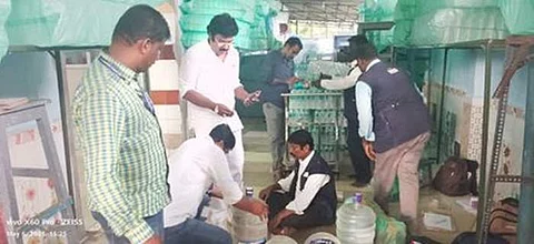 திருச்சியில் உரிமமின்றிச் செயல்பட்ட நிறுவனத்திலிருந்து தண்ணீா் பாட்டில்களை பறிமுதல் செய்த உணவுப் பாதுகாப்புத் துறை அலுவலா்கள்.
