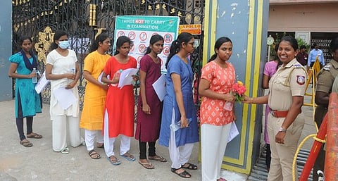 பாளையங்கோட்டை தூய யோவான் மேல்நிலைப் பள்ளியில் நீட் தோ்வு எழுத வந்த மாணவிக்கு மலரைக் கொடுத்து வாழ்த்து தெரிவித்த உதவி ஆய்வாளா் சுவாதிகா.