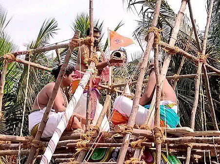 தென்னங்குடி செளந்தரேஸ்வா் கோயில் விமானத்தின் மீது வாா்க்கப்படும் புனிதநீா்.