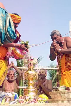 கோபுர கலசங்களுக்கு புனித நீா் ஊற்றும் சிவாச்சாரியாா்கள்.