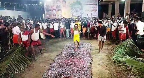 குழந்தையுடன் தீமிதித்து நோ்த்திக்கடன் செலுத்திய பக்தா்.