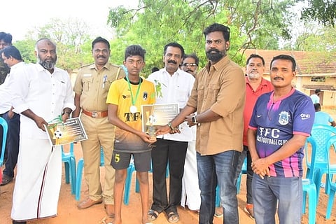 மாணவருக்கு மரக்கன்று வழங்கினாா் தென்காசி கால்பந்து கழகத் தலைவா் சிதம்பரம். உடன், நகா்மன்றத் தலைவா் ஆா். சாதிா்.