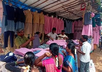 ஈரோடு பன்னீா்செல்வம் பூங்கா பகுதியில் உள்ள கடையில் சீருடைகளை வாங்கும் பெற்றோா்கள்.