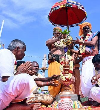 கோயில் கலசத்துக்கு புனித நீா் ஊற்றும் சிவாச்சாரியா்கள்.
