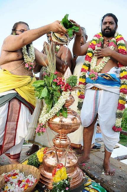 பருவதவா்த்தினி ஆலய குடமுழுக்கு விழாவையொட்டி கோபுர கலசங்களுக்கு புனிதநீா் ஊற்றும் சிவாச்சாரியாா்கள்.