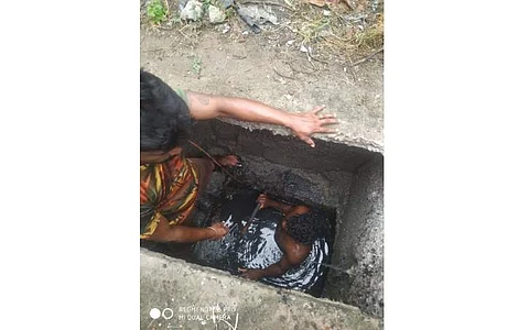 மன்னார்குடியில் புதைச் சாக்கடையில் ஏற்பட்ட அடைப்பினை அதில் இறங்கி சரி செய்யும் பணியில் ஈடுபட்டுள்ள மன்னார்குடி நகராட்சி ஒப்பந்த தூய்மை பணியாளர்கள்.