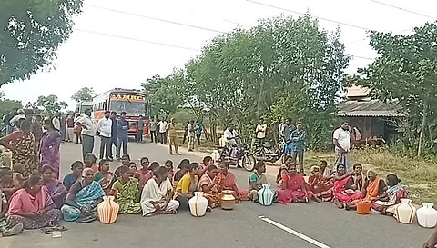 சாலையில் அமர்ந்து போராட்டத்தில் ஈடுபட்டு வரும் மக்கள் .