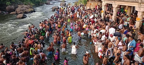 ஆடி அமாவாசையை முன்னிட்டு பாபநாசம் கோயில் படித்துறையில் புனித நீராடும் பக்தர்கள்