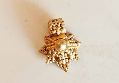 விருதுநகா் மாவட்டம், வெம்பக்கோட்டை அருகே இரண்டாம் கட்ட அகழாய்வின் போது வியாழக்கிழமை கண்டெடுக்கப்பட்ட 3 கிராம் எடை கொண்ட தங்கத் தாலி.