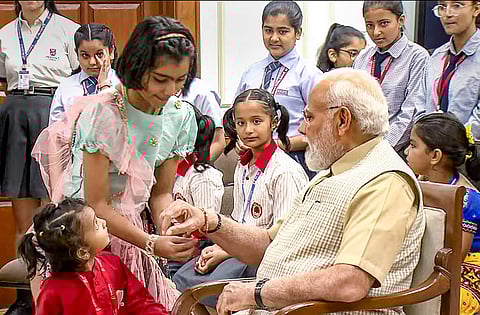 புதுதில்லியில் ரக்ஷா பந்தன் பண்டிகையை முன்னிட்டு பிரதமர் நரேந்திர மோடிக்கு ராக்கியை கட்டிய பள்ளி மாணவிகள்.