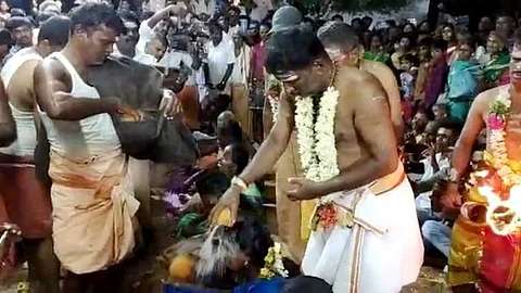 பேராம்பூர் வீரபத்திரர் கோயிலில் ஆடிப்பெருக்கு விழாவில் பக்தர்களின் தலையில் தேங்காய் உடைத்து ஆசீர்வாதம் ஆசீர்வாதம் வழங்கிய கோயில் பூசாரி.