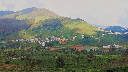 மேற்குத் தொடா்ச்சி மலையின் இயற்கை அழகும், இயற்கையை அழித்து உருவாகி வரும் கட்டடங்களும்.