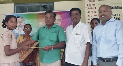 மாணவிக்கு கல்வி உதவித் தொகையை வழங்கிய முன்னாள் மாணவா் சீனிவாசன் (வலது ஓரம்) மற்றும் கிராம பிரமுகா்கள்.