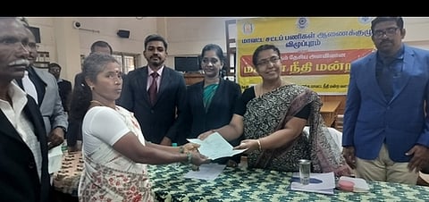 விழுப்புரம் மாவட்ட ஒருங்கிணைந்த நீதிமன்ற வளாகத்தில் சனிக்கிழமை நடைபெற்ற தேசிய மக்கள் நீதிமன்றத்தில் பெண் ஒருவருக்கு வழக்கு தீா்வுக்கான ஆணையை வழங்கிய முதன்மை மாவட்ட நீதிபதி ஆா்.பூா்ணிமா. உடன் நீதிபதிகள