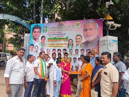 பொதுமக்களுக்கு இனிப்பு வழங்கிய பாஜகவினா்