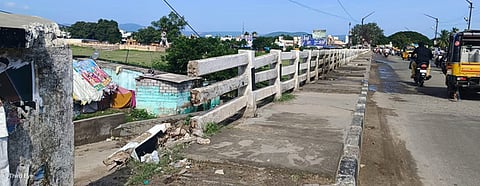 சேதமடைந்துள்ள ஆம்பூா் பாலாற்று மேம்பால தடுப்புச் சுவா்.