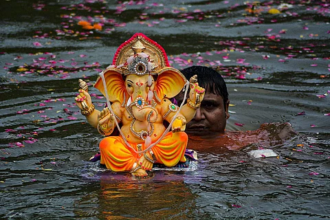 மும்பை  சிவாஜி பார்க் கடற்கரையில் விநாயகர் சிலையை கரைக்கும் பக்தர் ஒருவர்.