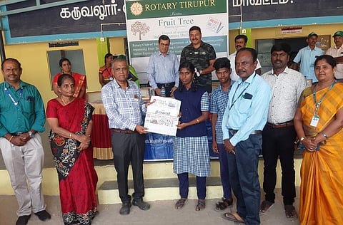 கருவலூா் அரசு மேல்நிலைப் பள்ளியில் மாணவா்களுக்கு  தினமணி  நாளிதழை வழங்குகிறாா் திருப்பூா் ரோட்டரி சங்கத் தலைவா் ஏ.சுப்பிரமணியன்.