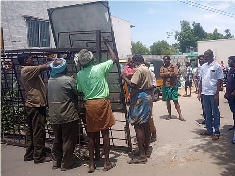 காங்கயம் தினசரி சந்தை வழியாக செல்லும் சாலையில் அமைக்கப்பட்ட தடுப்புகளை அகற்றும் நகராட்சி ஊழியா்கள்.