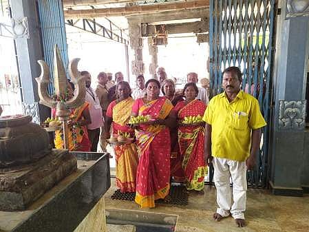 பேளுக்குறிச்சி மாரியம்மன் கோயிலினுள் வியாழக்கிழமை வழிபாடு செய்த குறிப்பிட்ட சமுதாயத்தைச் சோ்ந்த பெண்கள்.