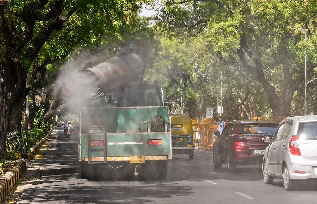 தில்லியில் சாலையில் நீர் தெளிக்கும் வாகனம்