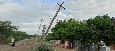 கமுதி சந்தனமாரியம்மன் கோயில் முன் சாய்ந்த மின் கம்பங்களை சீரமைக்க கோரிக்கை