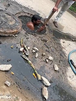 புதை சாக்கடை அடைப்பு: குழியில் இறங்கி தொழிலாளி சுத்தம் செய்த அவலம்