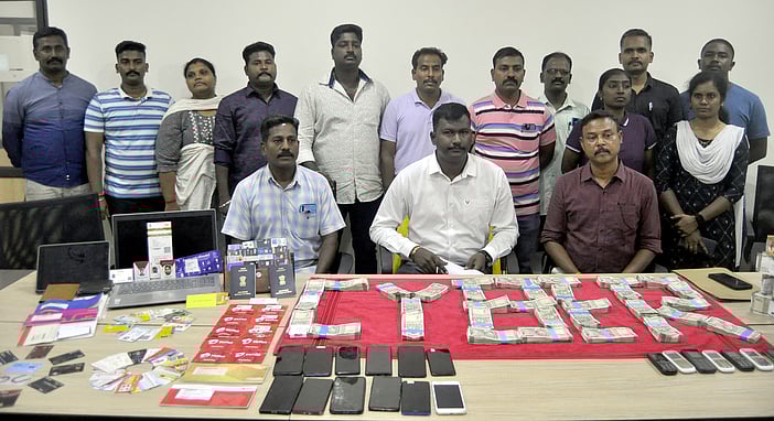 ~மோசடியில் ஈடுபட்ட இளைஞா்களிமிருந்து சனிக்கிழமை பறிமுதல் செய்யப்பட்ட பணம் மற்றும் ஏடிஎம் அட்டை உள்ளிட்ட பொருள்களுடன் சைபா் கிரைம் துறை முதுநிலை காவல் கண்காணிப்பாளா் கலைவாணன் மற்றும் போலீஸாா்.