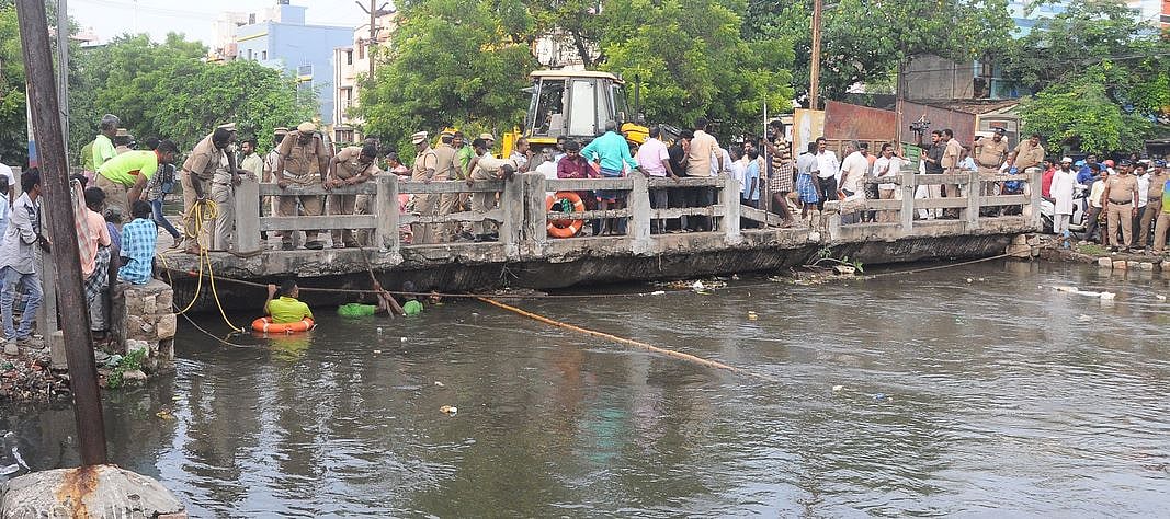 மதுரை, பந்தல்குடி கால்வாயில் புதன்கிழமை தண்ணீரில் இழுத்துச் செல்லப்பட்ட பாண்டிராஜனை தேடும் பணியில் ஈடுபட்ட தீயணைப்புத் துறையினா்