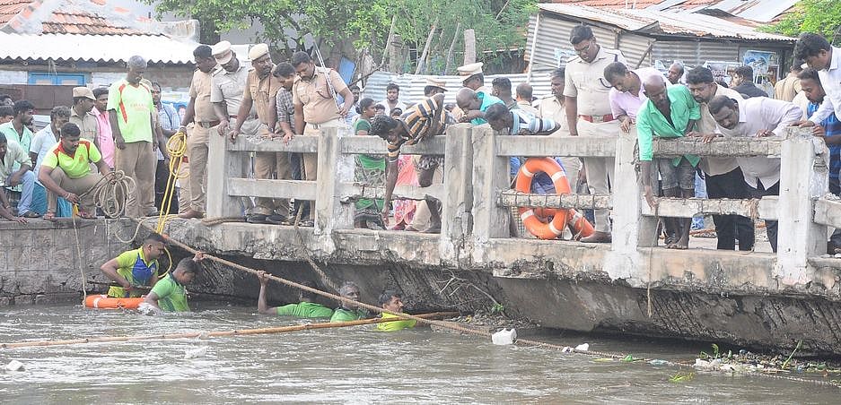 மதுரை, பந்தல்குடி கால்வாயில் புதன்கிழமை தண்ணீரில் இழுத்துச் செல்லப்பட்ட பாண்டிராஜனை தேடும் பணியில் ஈடுபட்ட தீயணைப்புத் துறையினா்