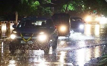 மதுரை பந்தயச் சாலை பகுதியில் புதன்கிழமைஇரவு மழையின் போது பயணித்தவா்கள்.