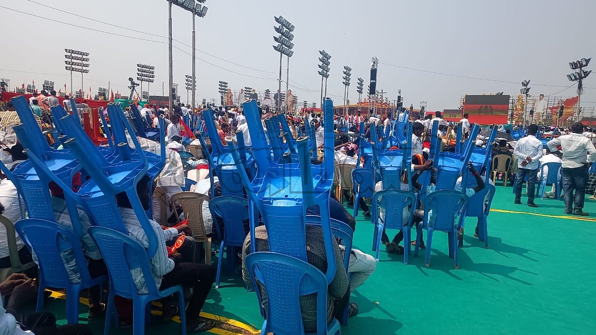 வெய்யிலால் தலையில் நாற்காலியுடன் அமர்ந்திருக்கும் தொண்டர்கள்