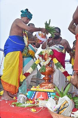 மதுரை எழுகடல் தெருவில் அமைந்துள்ள காஞ்சனமாலையம்மன் கோயில் கோபுரக் கலசத்தில் வியாழக்கிழமை புனிதநீா் ஊற்றி குடமுழுக்கு நடத்திய சிவாசாரியா்கள். குடமுழுக்கில் பங்கேற்ற பக்தா்கள்.