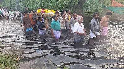 மயானச் சாலையில் தேங்கிய மழைநீா்: மாா்பளவு தண்ணீரில் இறுதி ஊா்வலம்