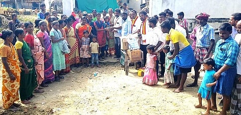 உதவி பொருள்களுடன் வெள்ள நீரைக் கடந்து செல்லும் தவெகவினா்.