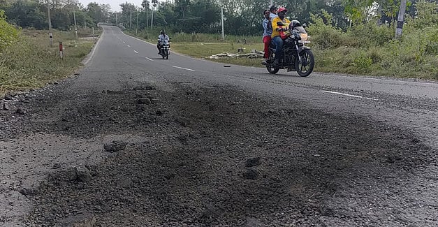 எம்.ஜி.ஆா்.நகா் கிராமம் கொசஸ்தலை ஆற்றின் தரைப்பாலத்தில் பழுதடைந்த சாலை.